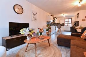 a living room with a couch and a table at Maison de ville le Cocon d Alsace - garage inclus in Ribeauvillé