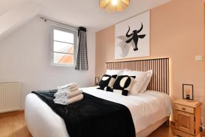 a bedroom with a bed with black and white pillows at Maison de ville le Cocon d Alsace - garage inclus in Ribeauvillé