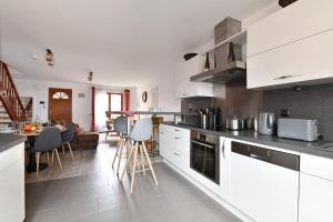 a kitchen with white cabinets and a living room at Maison de ville le Cocon d Alsace - garage inclus in Ribeauvillé +18 photos