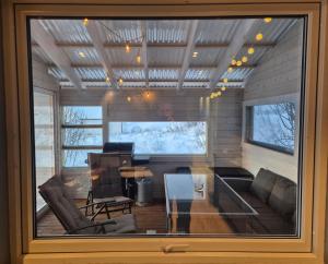 a living room with a table and a piano at Senja 4 Summit in Torsken