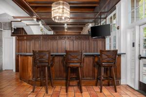 BakSonoma Stonehouse, King Room at Boutique Hotel的酒吧设有3张木凳和1台平面电视