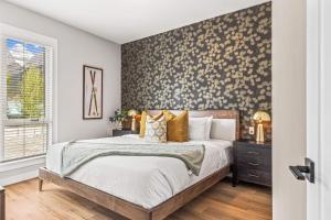 a bedroom with a bed with a floral accent wall at Luxury 4BR with Hot Tub Mtn Views 10Min Walk to DT in Canmore