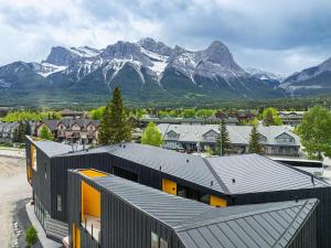 an aerial view of a building with mountains in the background at Luxury 4BR with Hot Tub Mtn Views 10Min Walk to DT in Canmore