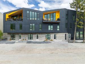 a large black building with a lot of windows at Luxury 4BR with Hot Tub Mtn Views 10Min Walk to DT in Canmore +71 photos