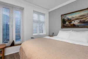 Un dormitorio blanco con una cama y un cuadro en la pared. en Prime location luxury apartment Reykjavik, en Reikiavik