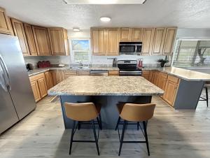 una cocina con una isla grande con 2 taburetes en Walker Ridge home, en Montrose 37 fotos más