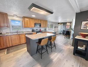 una cocina con armarios de madera y una gran isla con taburetes. en Walker Ridge home, en Montrose