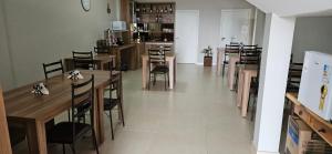 a dining room with wooden tables and chairs at Hotel Querência in Dionísio Cerqueira