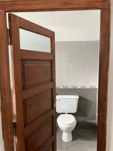 une salle de bain avec toilettes et porte en bois dans l'établissement Valle De Las Sierras Hotel, à La Falda 16 autres photos