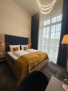 ein Schlafzimmer mit einem großen Bett mit einem großen Fenster in der Unterkunft H24 Parkhotel Thale in Thale