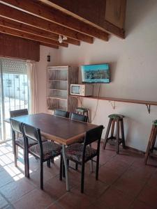 een eetkamer met een houten tafel en stoelen bij Del sur in Mar de Ajó