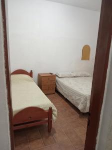 een slaapkamer met twee bedden, een ladekast en een spiegel bij Del sur in Mar de Ajó