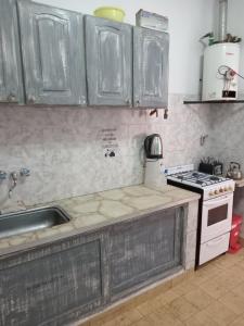 een keuken met een spoelbak en een fornuis bovenste oven bij Del sur in Mar de Ajó