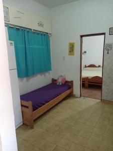 een slaapkamer met een bed met paarse lakens en een spiegel bij Del sur in Mar de Ajó