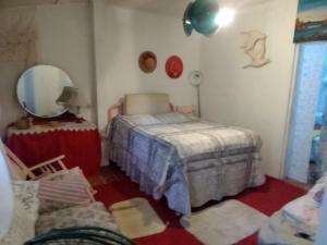 Una pequeña habitación con una cama y un espejo. en Captain Morgan House, en Kingston