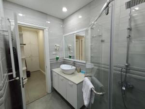a bathroom with a sink and a glass shower at Luxury 2 Bedrooms Apartment with 2 bathrooms & Batumi center in Batumi