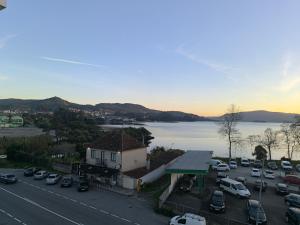 a parking lot with cars parked next to a lake at Hotel San Luis in Vilaboa