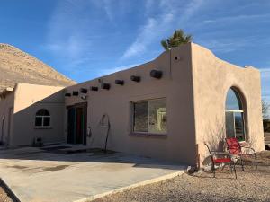 a house with two chairs sitting outside of it at Indian Ridge Casita in Willcox