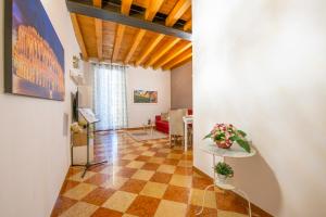 ein Flur mit einem Wohnzimmer und einem Tisch mit Blumen darauf in der Unterkunft Mazzini Luxury Suite in Verona