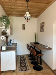 a kitchen with a wooden ceiling and a table and chairs at Panoráma Terasz Vendégház in Noszvaj