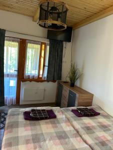 a bedroom with a large bed with a plaid blanket at Panoráma Terasz Vendégház in Noszvaj