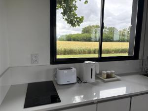 a kitchen counter with two toasters and a window at Aires de Capilla in Capilla del Señor +19 photos