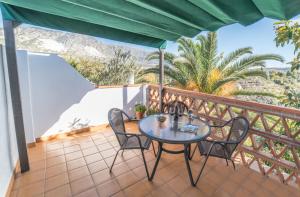 a patio with a table and chairs on a balcony at Casa El Olivo, Landhaus Mit Bergblick in Dúrcal +21 photos