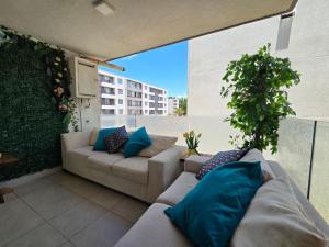 une terrasse avec deux canapés et une plante dans l'établissement Arriendo departamento en La Serena Central, à La Serena