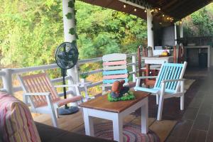 Posada Casa Tortuga, Zipolite في زيبوليت: مجموعة من الكراسي وطاولة على الشرفة