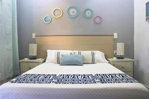 Posada Casa Tortuga, Zipolite في زيبوليت: غرفة نوم مع سرير كبير مع لوحات على الحائط