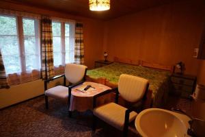 a bedroom with a bed and two chairs and a sink at Bühlengasse 6 in Grindelwald +16 photos