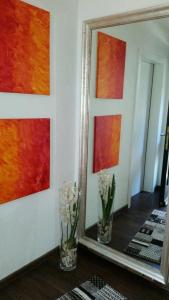 ein Spiegel und Vasen mit Blumen in einem Zimmer in der Unterkunft Ferienwohnung Himmelreich in Antfeld
