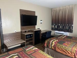 a hotel room with two beds and a desk with a television at Booneslick Lodge - Neosho in Neosho +30 photos