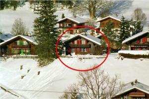 a red circle in the snow in front of a house at Chalet Gletscherfloh in Grindelwald