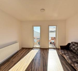 a living room with a couch and two windows at Świecie Apartament Biznesowy in Świecie