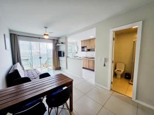 een woonkamer met een eettafel en een keuken bij PORTO AZUL - Praia do Forte - Apart in Cabo Frio