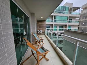 twee stoelen op het balkon van een gebouw bij PORTO AZUL - Praia do Forte - Apart in Cabo Frio