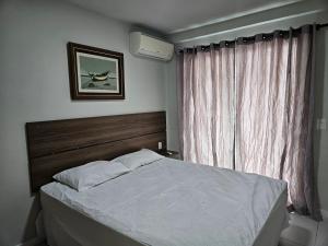 een slaapkamer met een groot bed en een raam bij PORTO AZUL - Praia do Forte - Apart in Cabo Frio