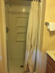 a shower with a white shower curtain in a bathroom at West Motel in Freeport