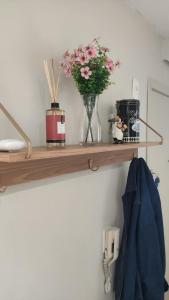 a wooden shelf with a vase of flowers on it at Apartamento completo e com ar-condicionado in Bento Gonçalves