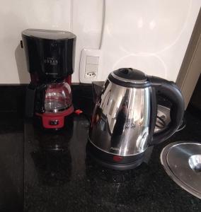 a tea kettle next to a coffee maker on a counter at Apartamento completo e com ar-condicionado in Bento Gonçalves +4 photos