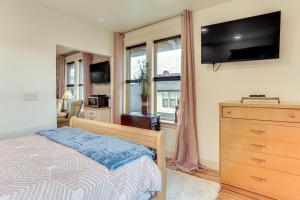 安娜柯蒂斯Extended PNW Retreat in Historic Dtwn Anacortes!的一间卧室配有一张床和一个带电视的梳妆台。