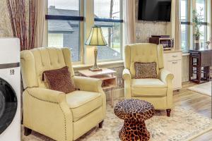 安娜柯蒂斯Extended PNW Retreat in Historic Dtwn Anacortes!的客厅配有两把椅子和一张搁脚凳