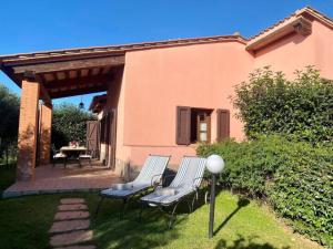 twee stoelen en een tafel op een patio bij Appartamento Papavero Seaside and Pool in La Caduta