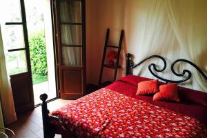 een slaapkamer met een bed met een rood dekbed bij Appartamento Papavero Seaside and Pool in La Caduta