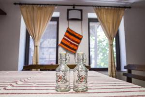 two glass bottles sitting on top of a table at Topalovi Guest House in Zlatograd