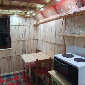 a kitchen with a stove and a wooden table at Studio apartman Planinska Bajka in Olovo