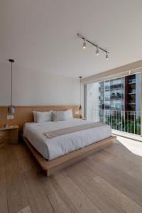 una camera da letto con un letto grande e una grande finestra di Capitalia Antara Polanco a Città del Messico