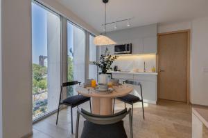 una cucina e una sala da pranzo con tavolo e sedie di Capitalia Antara Polanco a Città del Messico