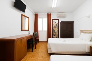 une chambre d'hôtel avec deux lits et un bureau dans l'établissement DBV Guesthouse, à Lagos